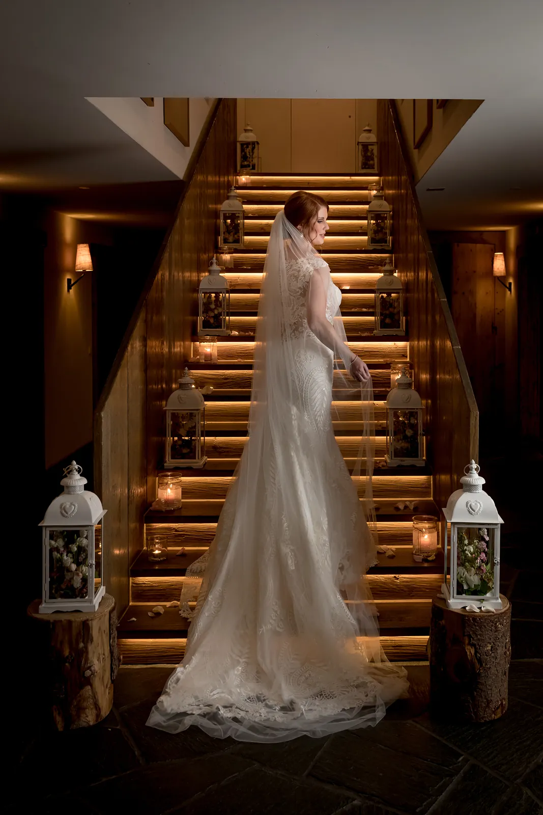 Braut im Schleier auf der beleuchteten Holztreppe im Maiensässhotel Guarda Val, Lenzerheide