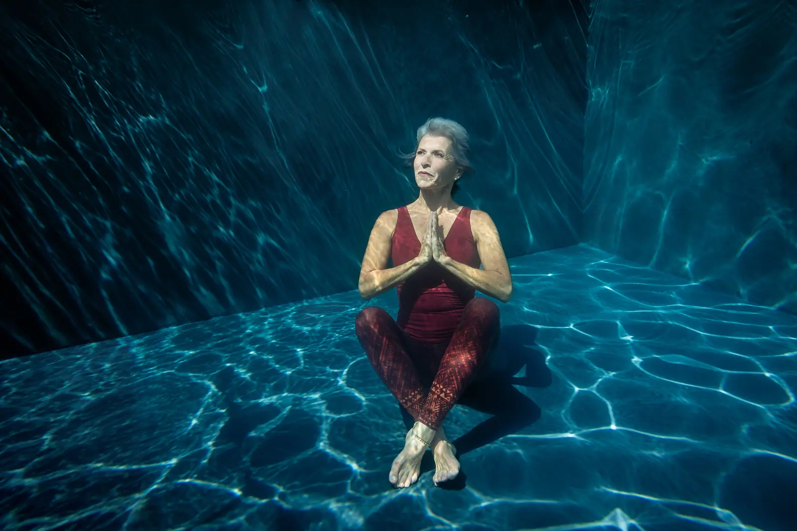 Yogalehrerin Monika im Lotussitz auf dem Beckenboden, Unterwasser-Businessfoto