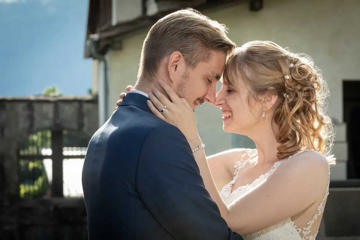 Brautpaar Stirn an Stirn, lachend im Gegenlicht – Hochzeitsfotografie in Graubünden